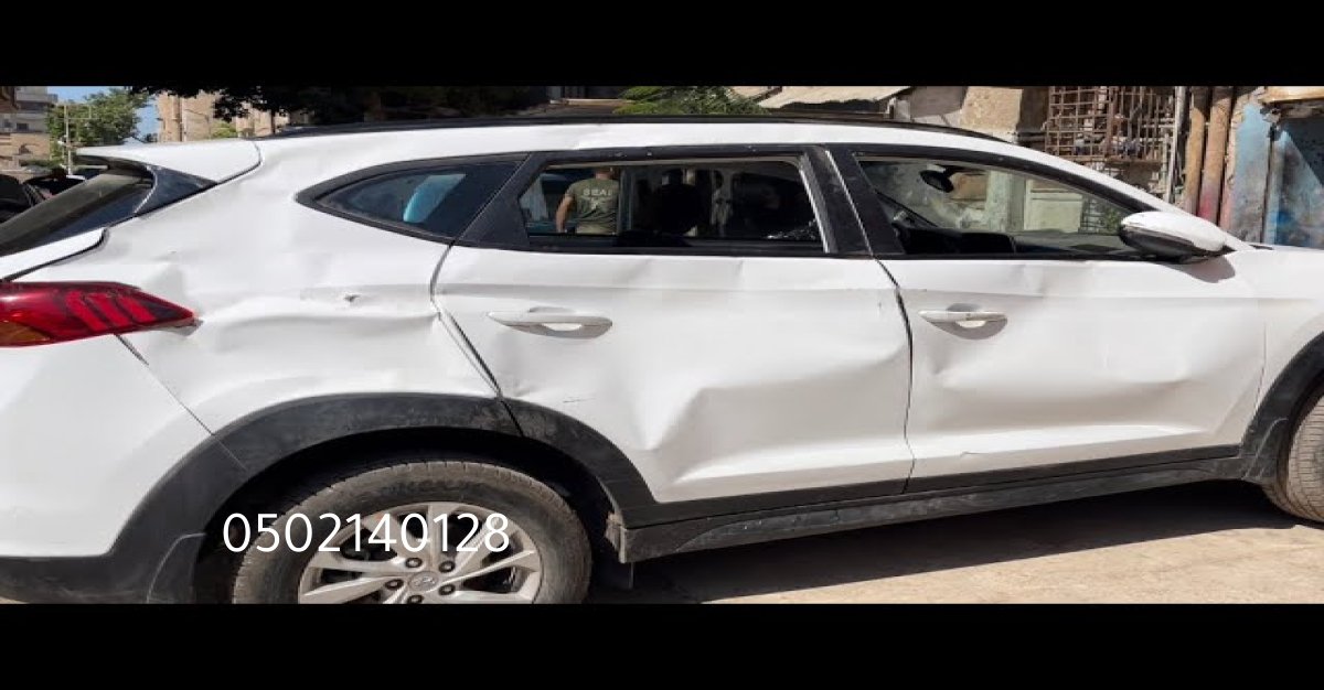 عكس سيارة مفكوك على الأرض بانتظار الإصلاح في ورشة بالرياض.