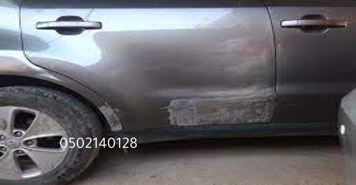 فني سمكرة يعمل على تقويم رفرف برادو في ورشة بالرياض.