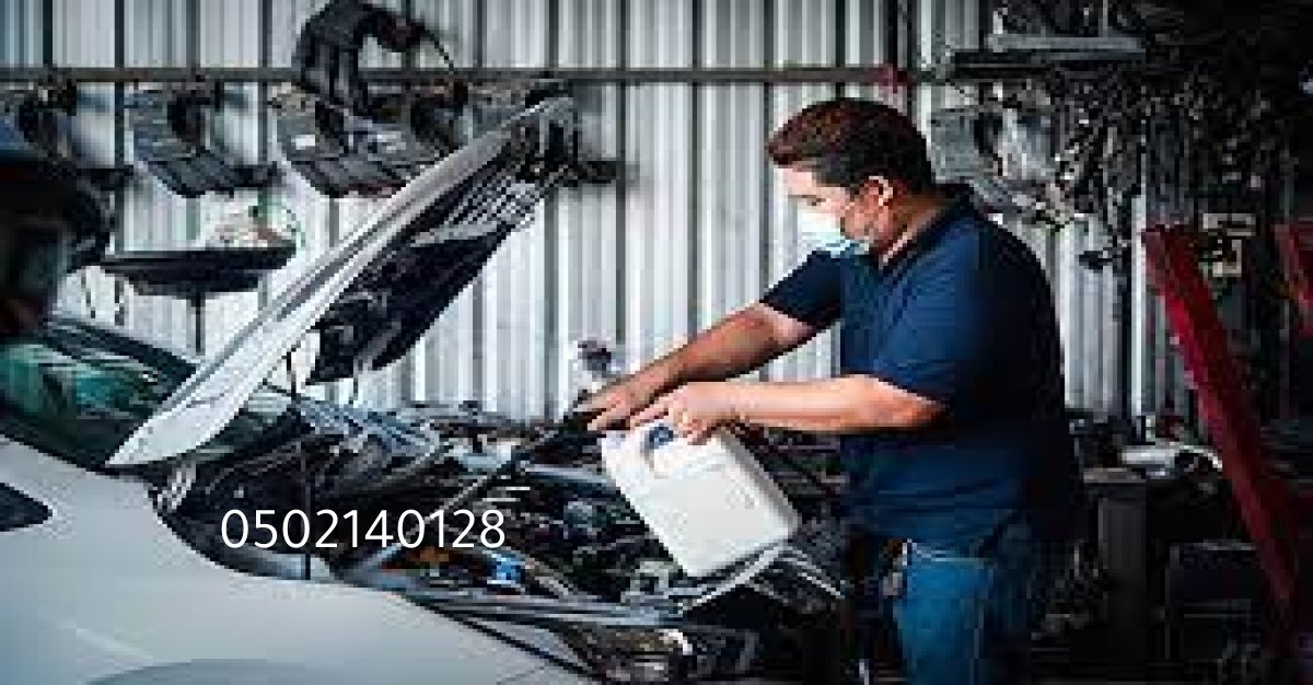 فني يقوم بتنظيف بخاخات سيارة باستخدام جهاز مخصص في ورشة بالرياض.