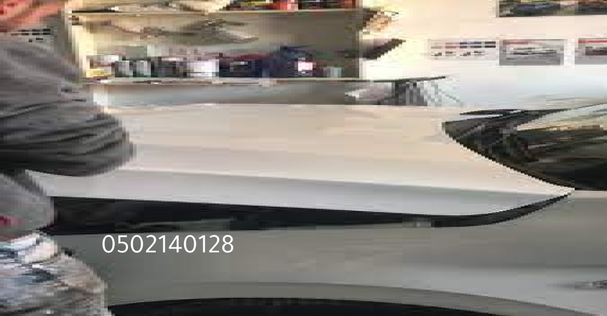 لقطة قريبة لإصلاح صدمة في باب سيارة برادو داخل ورشة معتمدة.