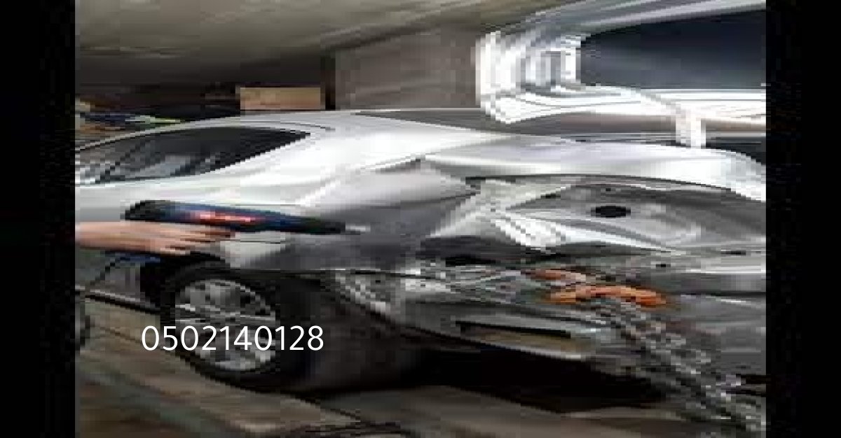 ورشة سمكرة سيارات في الرياض تُظهر فنيين يعملون على إصلاح الهيكل.